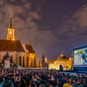 A photograph of Union Square in Cluj-Napoca, Romania, hosting an open air screening of the Transilvania International Film Festival. TFV Network offers podcast coverage of this event.